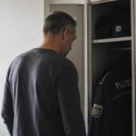 Polizeibeamter blickt still in einen halb geöffneten Spind mit Dienstkleidung – Symbolbild für Polizei Burnout und inneren Abschied vom Polizeidienst